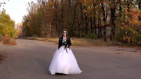 A-young-girl-with-a-creepy-make-up-in-the-form-of-a-skull-going-on-an-empty-road