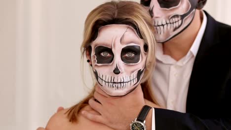 Un-hombre-con-maquillaje-de-Halloween-está-sosteniendo-A-su-novia-en-el-cuello.