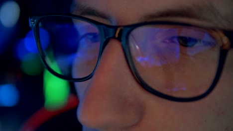 Close-up-of-gamer's-glasses-with-a-videogame-reflecting-in-them