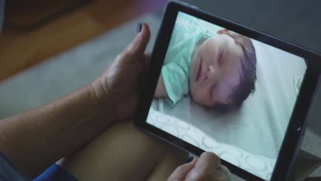 Zeitlupe-der-Großmutter-lächelnd,-als-sie-Baby-durch-Tabletsieht