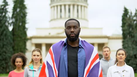 Hombre-negro-enojado-levantando-bandera-de-Gran-Bretaña,-protesta-del-brexit,-crisis-migratoria