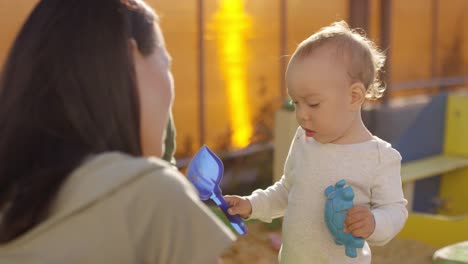 Woman-Talking-to-Misbehaving-Toddler-in-Sand-Box