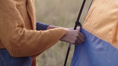 Nahaufnahme-von-Hand-asiatische-kleine-Mädchen-half-ihrer-Mutter-Pitch-Zelt-im-Winter-am-Morgen.-Das-Konzept-des-Familienlebens-im-Urlaub