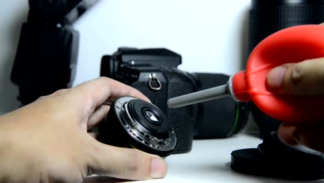 DSLR-camera-lens-cleaning-by-blowing-dust-of-the-lens