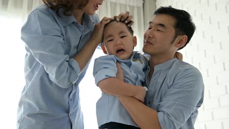 Parents-came-to-comfort-half-Japanese-boy-after-slipped-and-his-head-hit-by-floor-until-he-cried.-Happy-family-and-baby-of-Multi-ethnics-mixed-race-people-concept.-Appreciate-parenthood-and-child