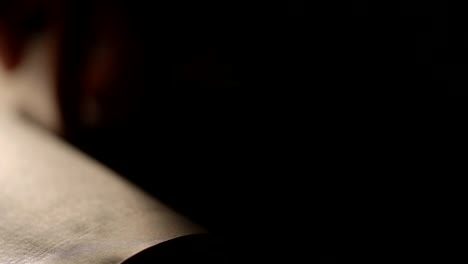 Hand-leafing-through-an-old-book-pages-closeup