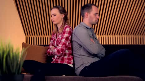 Offended,-angry-couple-sitting-on-sofa-at-home