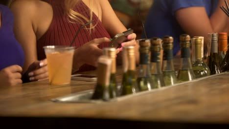 Glamorous-blonde-ladies-watching-video-on-smartphone,-having-fun-at-party-in-bar