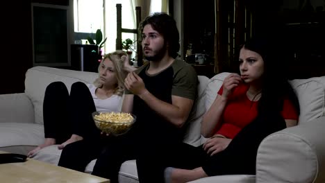 Freunde-Essen-Popcorn-und-Horror-Film-mit-sehr-ausdrucksstarken-Gesichter