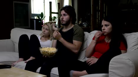 Friends-eating-popcorn-and-watching-horror-movie-with-very-expressive-faces