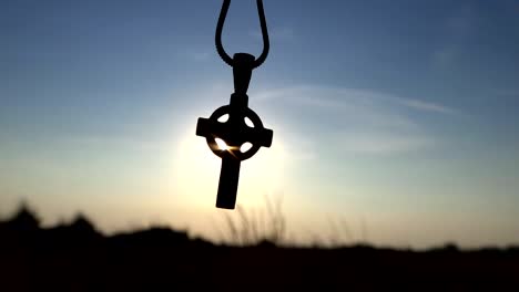 Closeup-Of-Silhouette-Cross-Hanging-at-sunset/sunrise-time