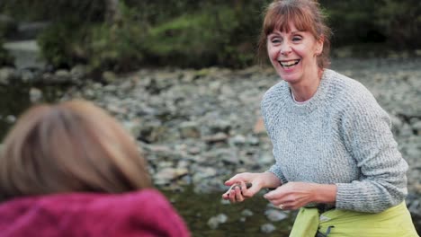 Zwei-Frauen-Skimming-Steinen-auf-dem-See