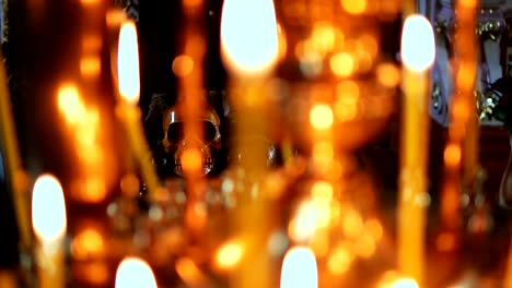 Skull-on-background-in-focus,-in-the-foreground-burning-candles