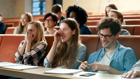 Multi-ethnischen-Gruppe-von-Studenten-schreiben-Down-nach-Dozent-starten-Sie-lachen.-Helle-junge-Leute,-die-Spaß-an-der-Universität.