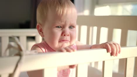 Sad-baby-crying-in-cot-at-home.-Unhappy-toddler-standing-in-crib