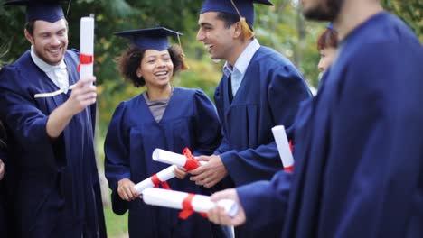 glückliche-Schüler-in-Mörtel-Boards-mit-Diplomen