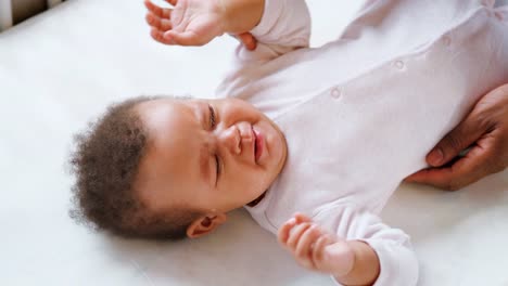 Padre-a-hija-llorando-tranquilizador-acostado-en-la-cuna