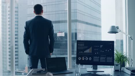 Thoughtful-Businessman-in-a-Suit-Standing-in-His-Office,-Looking-out-of-the-Window-and-Contemplating-Next-Big-Business-Contract.-Major-City-Business-District-with-Panoramic-Window-View.