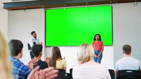 Female-Student-Giving-Presentation-To-High-School-Class-In-Front-Of-Screen