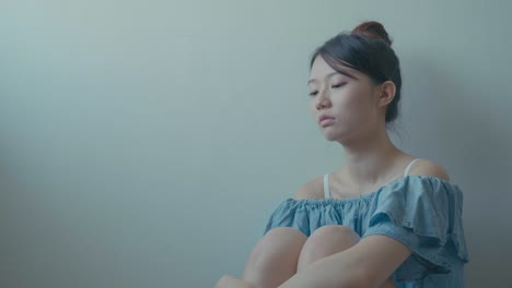 Sad-woman-sitting-alone-in-a-empty-room