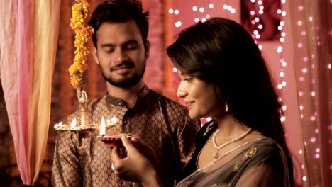 A-happy-and-attractive-couple-in-a-house-interior-decorated-with-lights-and-flowers.