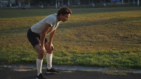 Joven-atleta-de-raza-mixta-tomando-un-respiro-de-descanso-después-de-correr-el-sprint