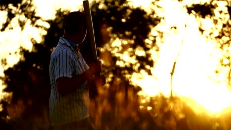 Men's-baseball-practice-hitting-a-baseball-with-the-light-of-sunset