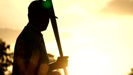 Männer-sind-den-Baseball-Spieler-mit-dem-Sonnenuntergang-schlagen.