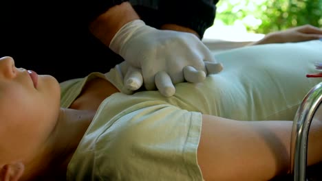 Paramedic-doing-CPR-to-woman,-colleague-filling-papers,-professional-saving-life