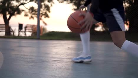 Imágenes-de-un-jugador-de-baloncesto-niña-formación-y-ejercicio-al-aire-libre-en-la-corte-local-de-cerca.-Usar-ropa-deportiva-y-calcetines-blancos,-zapatillas-de-deporte