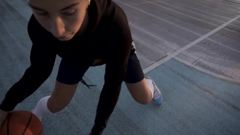 Female-basketball-player-in-morning-light-on-professional-court-running-with-ball.-Handhelded-footage.-Close-up