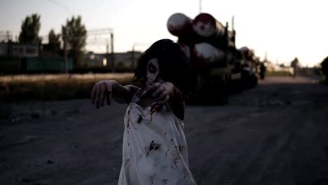 Creepy-zombie-woman-with-wounded-face-walking-outdoors-with-an-industrial-abandoned-place-on-the-background.-Halloween,-filming,-creepy-concept