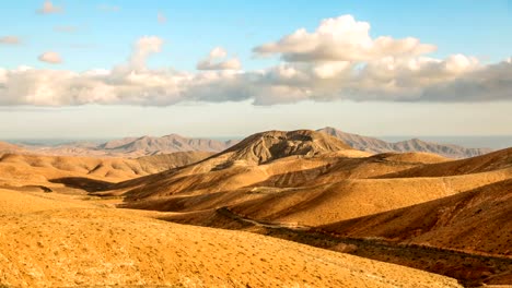 Timelapse-clouds-flying-over-dry-mountains-and-smooth-hills,-Fuerteventura,-Spain