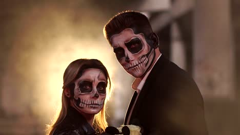 Couple-with-dark-skull-makeup-on-the-background-of-burning-fire-and-smoke.