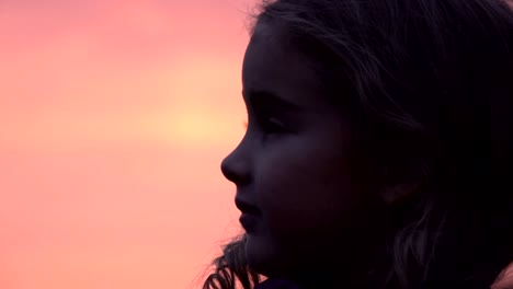 Niño-mirando-el-cielo-en-la-naturaleza.-Niña-rezando-mirando-hacia-arriba-en-el-cielo-púrpura-con-esperanza,-Close-up.