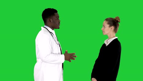 Male-african-doctor-talking-to-female-patient-on-a-Green-Screen,-Chroma-Key