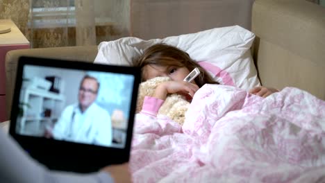 Mom-with-a-little-sick-daughter-gets-a-doctor's-consultation-using-video-chat-at-home.