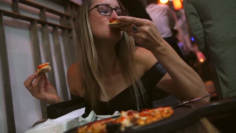 Kaukasische-Frau-genießen-cheesy-Pizza-in-eine-late-Night-Imbiss-stand