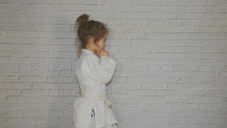 girl,--child-in-a-kimono-on-karate-training-works-out-blows-and-greeting