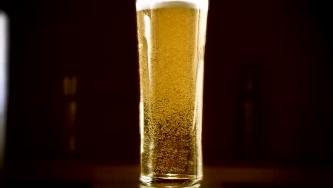 Close-up-slow-motion-Cold-Light-Beer-in-a-glass-with-water-drops-on-bar-background.-Craft-Beer-close-up