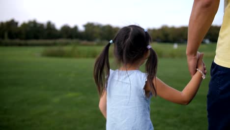 Asian-father-and-daughter-holding-hands-and-walking