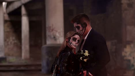 Couple-with-dark-skull-makeup-on-the-background-of-burning-fire-and-smoke.