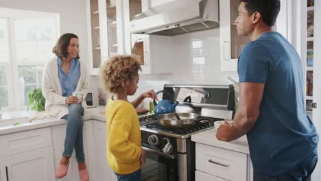 Mixed-race-parents-and-their-pre-teen-daughter-preparing-food-together-in-the-kitchen