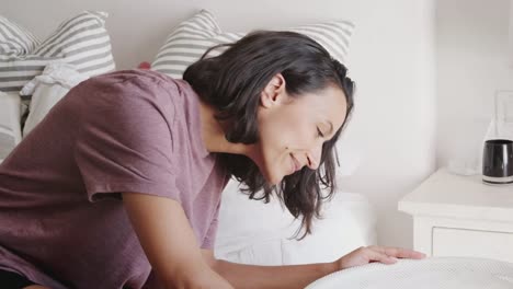 Millennial-mother-gets-up-to-check-on-her-baby,-sleeping-in-the-crib-beside-her-bed