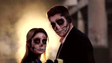 Couple-with-dark-skull-makeup-on-the-background-of-burning-fire-and-smoke.