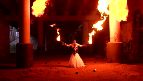 A-couple-in-wedding-dresses-and-with-makeup-for-Halloween-perform-a-fire-show.