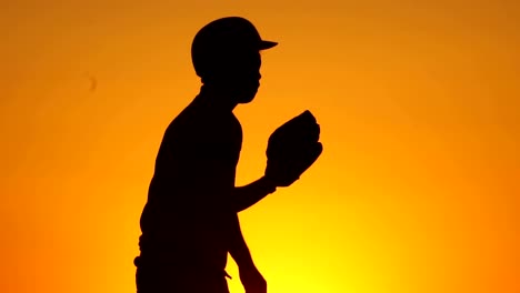 Silhouette-man-with-a-baseball-glove-catching-a-baseball