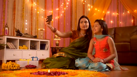 Ocasión-del-festival---joven-madre-india-está-haciendo-clic-en-un-selfie-con-su-hija.-Decoración-Diwali