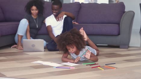 Kid-drawing-parents-using-notebook-spending-time-on-heated-floor