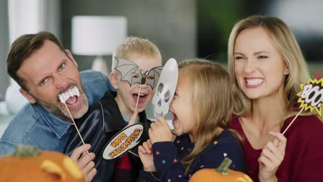 Porträt-der-verspielten-Familie-mit-Masken-während-Halloween